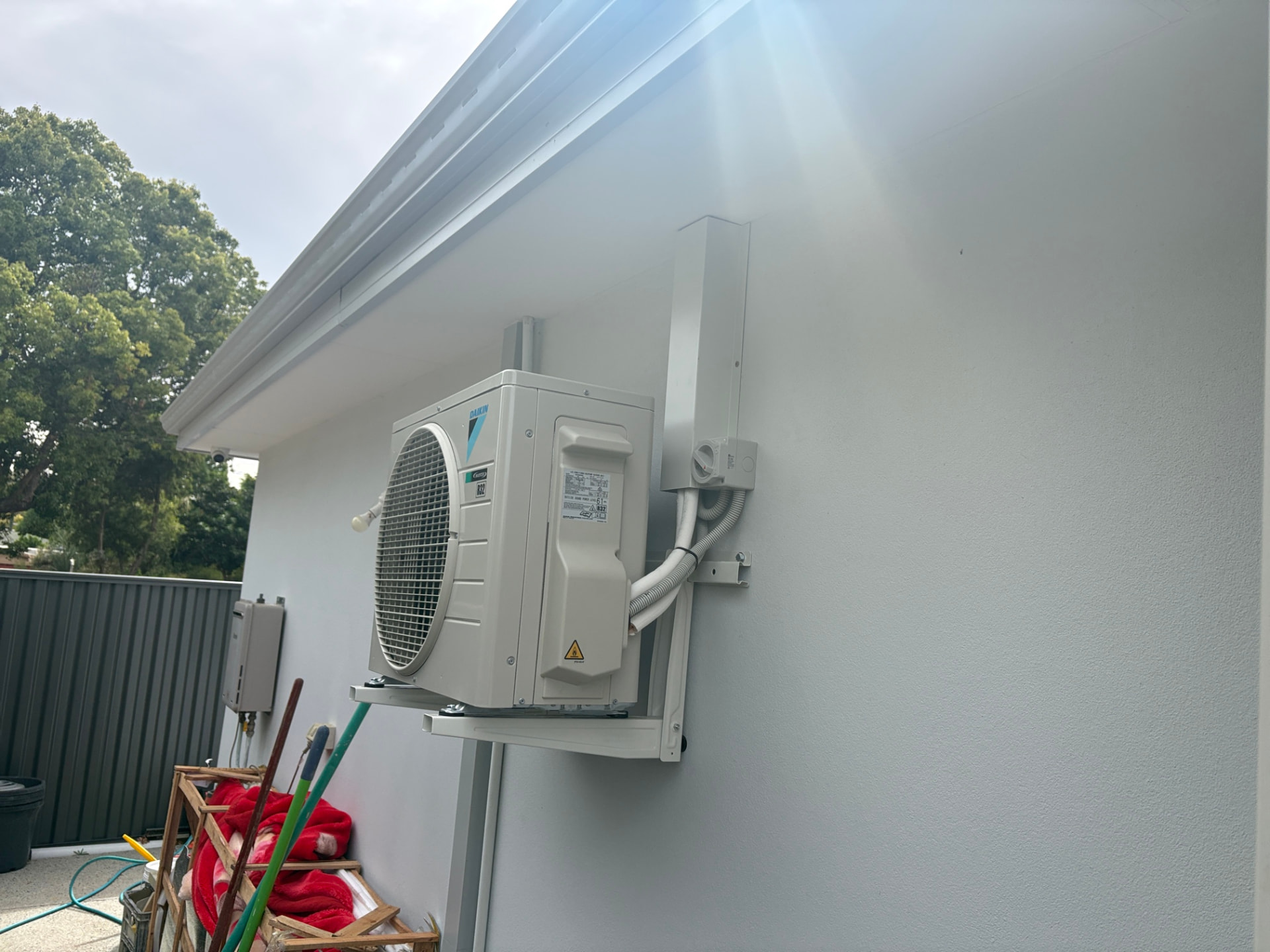 Daikin split-system outdoor unit mounted on a neat wall bracket with tidy pipework
