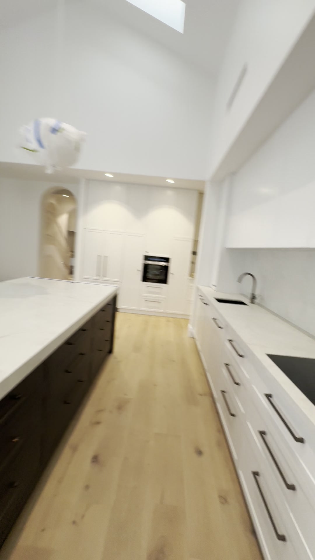 Induction cooktop and under-cabinet LED strip lighting on a marble-look splashback, Nedlands kitchen renovation